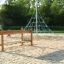 Children playing on Classic Nature Trim Trail at a playground with a rope climbing pyramid.