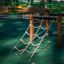 Classic Nature Trim Trail wooden climbing structure with rope net on playground.