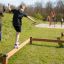 Children playing on the Classic Nature Trim Trail balance beams in a park setting.