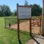 Outdoor information board at a playground with surrounding greenery
