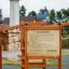 Rules Tab playground equipment with safety instructions sign on wooden frame outdoors