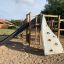 Playground equipment Challenger Aztec Nature II with a slide and climbing wall.