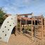 Playground climbing structure Challenger Aztec Nature II with wooden frame and climbing wall.