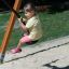 Child swinging on a rope swing at playground.