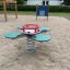 Green and red Clover rocking playground spring rider on sandy area