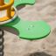Clover rocking playground equipment close-up on sand background.