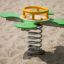 Green and yellow Clover rocking playground equipment on sand.