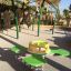 Green and yellow Clover rocking play equipment in a sunny playground