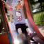 Two children playing on a locomotive playhouse with a slide.