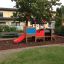 Locomotive with slide train playhouse in playground with wood chip ground cover.