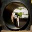 Wooden train-themed playhouse with yellow accents viewed through a circular tunnel.