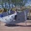 Children playing on Aztec play loop steel structure in a playground.