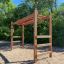 Wooden outdoor playground ladder with horizontal bars and climbing steps.