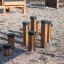 Wooden Jumping pegs playground equipment on gravel surface.