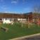 Outdoor playground with Jumping Pegs equipment, climbing nets, and slides on artificial grass.