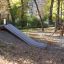 Hill Slide h150 in a playground surrounded by trees in autumn.