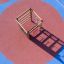 Wooden climbing box playhouse on colorful playground surface.
