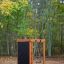 Wooden playhouse with climbing wall in a forest playground.