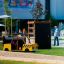 Climbing box wooden playhouse in the shape of a yellow taxi with climbing wall in a playground.