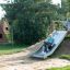 Child sliding down a Hill Slide Wide h150 in a playground.