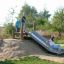 Children playing on Hill Slide Wide h150 in a park.
