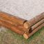 Wooden 5-angle palisade sandbox corner on a patch of grass.