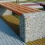 Concrete and wooden bench Wika in an outdoor park setting.