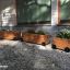 Wooden flowerpot II in different sizes used as outdoor plant containers.
