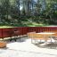 Wooden flowerpot II on a spacious outdoor deck area with a table set and metal grill.