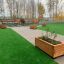Wooden flowerpot II on a rooftop garden with benches and greenery.