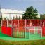 Red and white Allianz Arena playground structure in a grassy field.