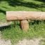 Wooden balance beam for outdoor play in a park setting.