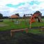 Double swing in a playground with other play structures.