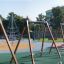 Swing Frame (double swing) in a colorful playground with other play structures in the background