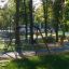 Swing Frame (double swing) in a sunny green park with trees in the background