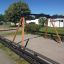 Swing Frame (double swing) in a playground with wooden support beams and a sand surface.