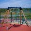 Swing Frame (single swing, wide) with wooden posts and circular swing seat on playground