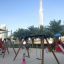 Swing Frame (single swing, wide) in a sunny playground with children playing.