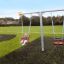 Swing Metal Frame (double swing) with a child on one seat in a green playground