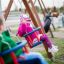 Children playing on a swing seat: Baby seat in a playground.