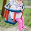 Baby sitting in a blue and red Swing seat: Baby seat.