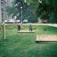 Swing seat: Flexi seat in a green park with sandboxes and children playing