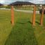Swing seat: Flexi seat installed outdoors in a grassy area with wooden pillars.