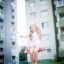 Child on red Swing Seat: Safety Seat in playground area with buildings in the background