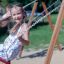 Child playing on swing seat: Safety seat in playground
