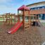 Lemur single slide on a playground with a wooden structure and red roof