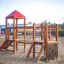 Playground equipment Lemur single slide with climbing and balancing structures.