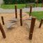 Playground equipment Kentucky Double with wooden posts and connected stepping platforms in an outdoo