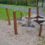 Playground equipment 'Kentucky Double' with wooden posts and black plastic platforms chained togethe