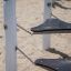 Kentucky Double playground equipment with wooden posts and suspended steps on a sandy surface.